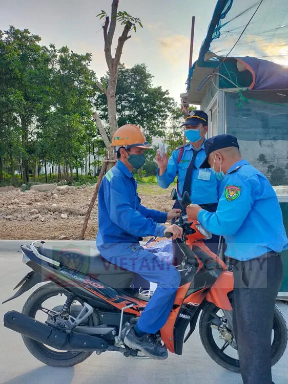 Nhân viên bảo vệ thực hiện đo nhiệt độ cho mọi người trước khi vào khu nghỉ dưỡng Nhân viên bảo vệ thực hiện đo nhiệt độ cho mọi người trước khi vào khu nghỉ dưỡng